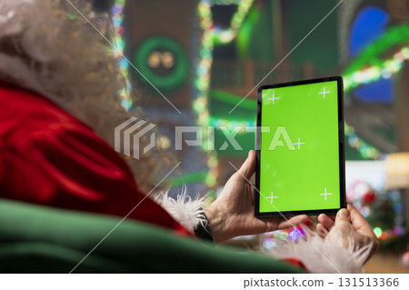 Person dressed as Santa Claus using mockup digital tablet to read letters from kids. Man portraying Father Christmas answering emails received from children using isolated screen touchscreen device Person dressed as Santa Claus using mockup digital tablet to read letters from kids. Man portraying Father Christmas answering emails received from children using isolated screen touchscreen device 131513366