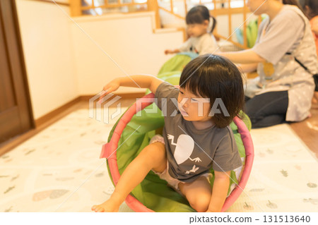 Toddler girl playing on tunnel play equipment Toddler girl playing on tunnel play equipment 131513640