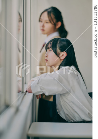 Junior high school girls talking by the window Junior high school girls talking by the window 131513786