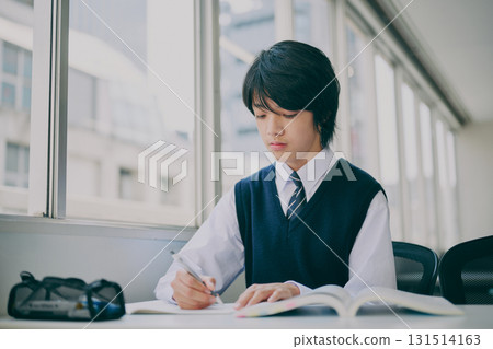 Male junior high school student studying in a cram school classroom Male junior high school student studying in a cram school classroom 131514163