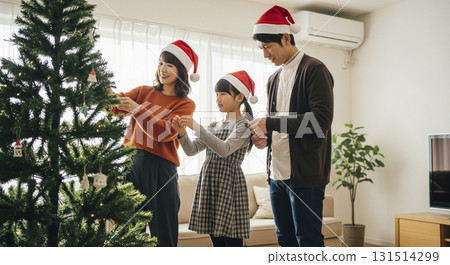 Family decorating the Christmas tree 131514299