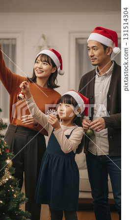 Family decorating the Christmas tree 131514304