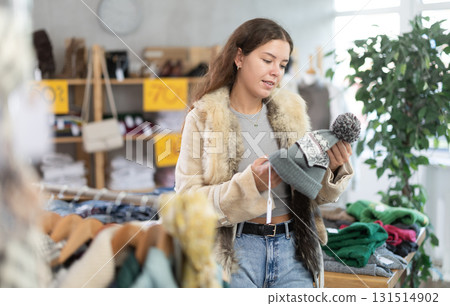 Young girl choosing hat in clothing store 131514902