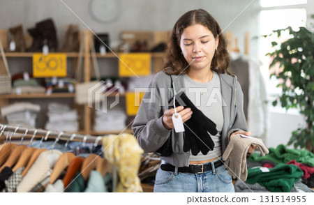 Young woman choosing gloves in clothing store Young woman choosing gloves in clothing store 131514955