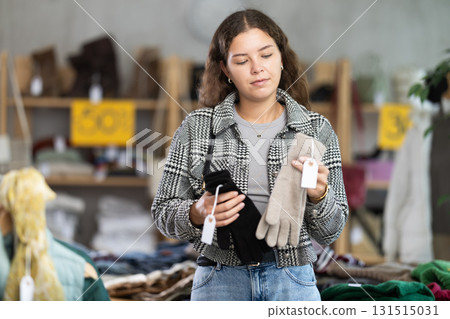 Young woman choosing gloves in clothing store 131515031