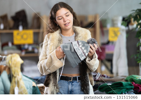 Young woman choosing hat in clothing store 131515066