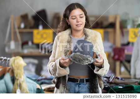 During November sales, young woman choose and buy fur hat 131515090