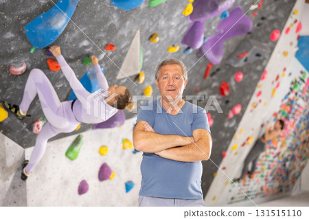 Positive senior coach man on the background of climbing wall Positive senior coach man on the background of climbing wall 131515110