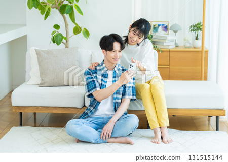 夫婦在客廳裡看智能手機 131515144