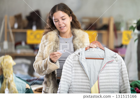 During November sales, young woman choose and buy down coat During November sales, young woman choose and buy down coat 131515166