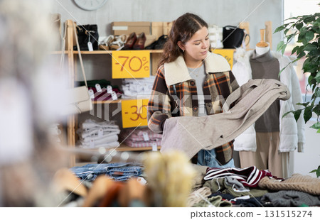 Selective young woman choosing trousers in clothing store Selective young woman choosing trousers in clothing store 131515274
