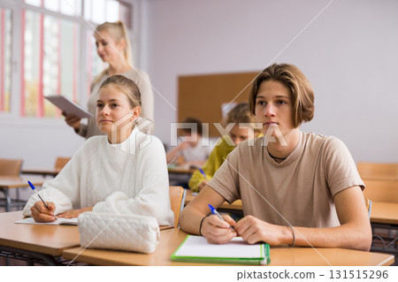 Teenage pupils sitting at desk in classroom Teenage pupils sitting at desk in classroom 131515296