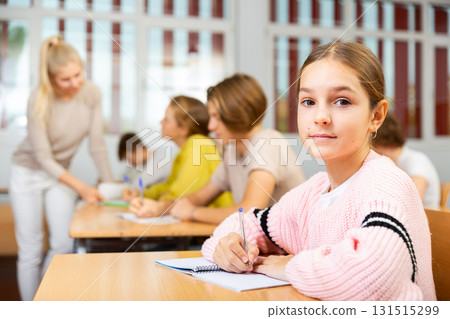 Young girl sitting at desk in classroom 131515299