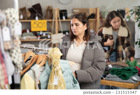 Adult woman choosing winter clothes in store Adult woman choosing winter clothes in store 131515347