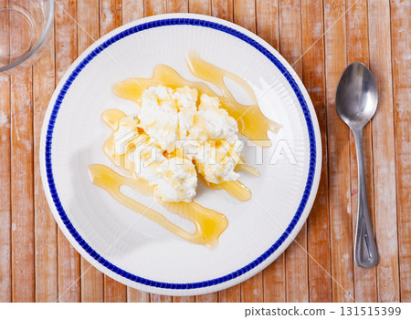 Soft cheese with honey in white plate Soft cheese with honey in white plate 131515399