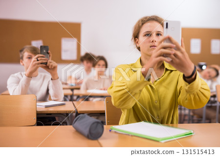 Classmates using their smart phones heavily during classes Classmates using their smart phones heavily during classes 131515413