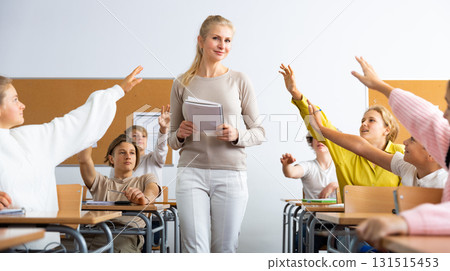 Students raise their hand to answer during lesson in class Students raise their hand to answer during lesson in class 131515453