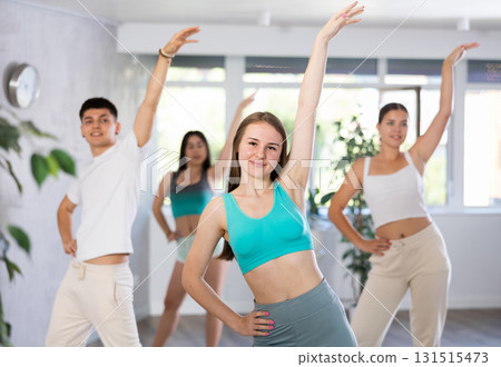 Girl teen perform choreographic exercise and teach energetic waacking dance with friends Girl teen perform choreographic exercise and teach energetic waacking dance with friends 131515473