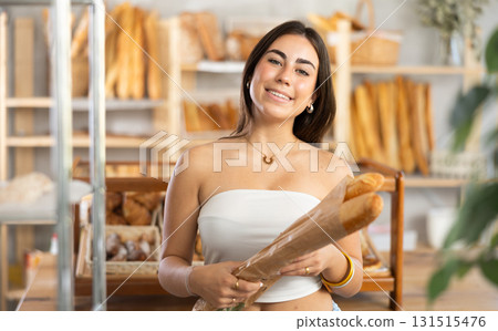 Young woman buying baguettes in bakery 131515476
