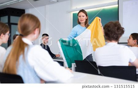 Adult teacher showing students the flag of Ireland 131515515