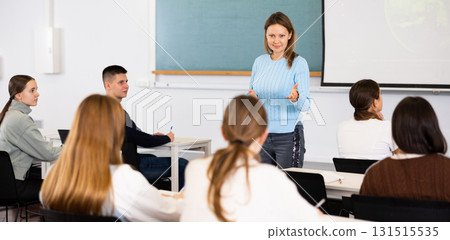 Female professor talks to students in classroom Female professor talks to students in classroom 131515535