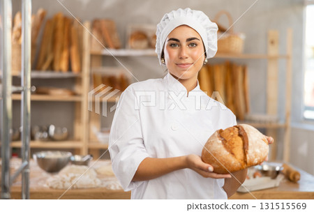 Young female baker with homemade bread Young female baker with homemade bread 131515569