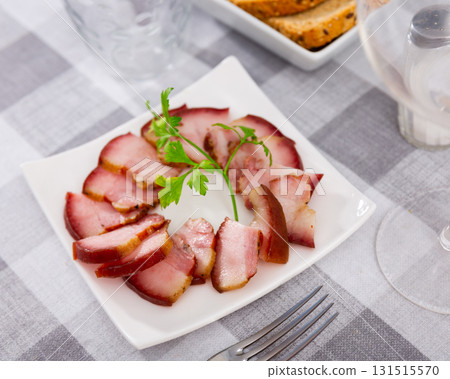 Delicious smoked lard, sliced with greens on white plate Delicious smoked lard, sliced with greens on white plate 131515570