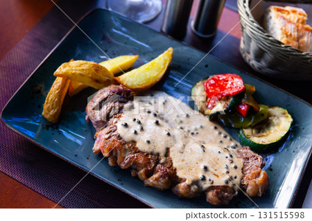 Veal steak with piquant creamy sauce, potatoes and vegetables Veal steak with piquant creamy sauce, potatoes and vegetables 131515598