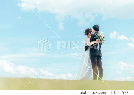 新娘和新郎在天空背景下接吻（婚禮、婚禮、新娘、外景照片） 131515771