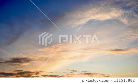 Orange-pink sunrise clouds on a deep blue morning sky. Orange-pink sunrise clouds on a deep blue morning sky. 131515998