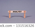 Analyst symbol. Single Wooden stick restrained by Clothespins, beautiful Gray Background. Business and Analyst concept with copy space 131516326