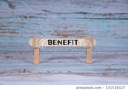 Benefit symbol. Single Wooden stick squeezed by Clothespins, Grungy blue Wooden Texture Background. Business and Benefit concept with copy space 131516327