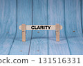 Clarity symbol. Wooden stick clamped by Clothespins, vivid blue wooden backdrop. Business and Clarity concept with copy space 131516331