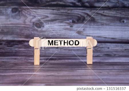 Method symbol. A wooden stick secured by Clothespins set over beautiful Realistic Wooden Texture Background. Business and Method concept with copy space 131516337