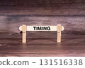 Timing symbol. Clothespins gripping a wooden stick against a beautiful Brown Wooden Background . Business and Timing concept with copy space 131516338