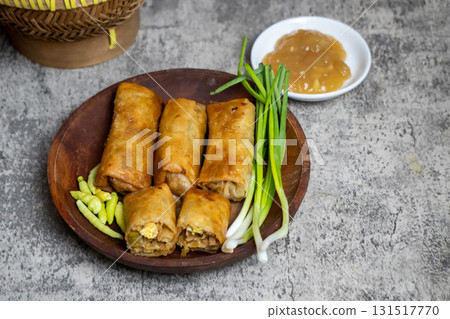 Authentic Lumpia Semarang or Indonesian fried spring rolls filled with bamboo shoots, egg, and chicken, served with fresh greens. Authentic Lumpia Semarang or Indonesian fried spring rolls filled with bamboo shoots, egg, and chicken, served with fresh greens. 131517770
