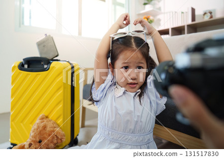 Family Travel. Child posing with sunglasses while preparing for a trip. Family Travel. Child posing with sunglasses while preparing for a trip. 131517830