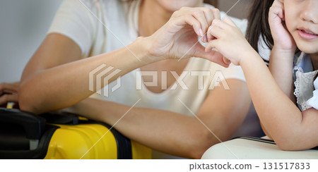 Family Connection. Mother and daughter sharing a playful moment with luggage. 131517833