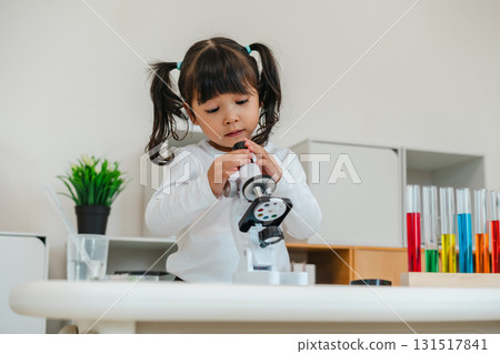 happy toddler girl scientist learning science with microscope 131517841
