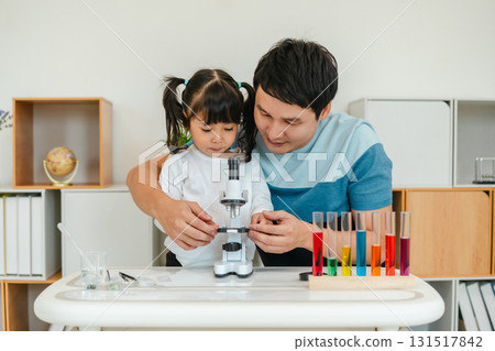 father and toddler girl scientist placing microscope slides with specimen. learning science 131517842