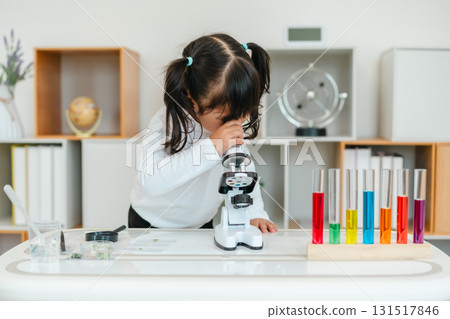 toddler girl scientist looking through microscope. learning science toddler girl scientist looking through microscope. learning science 131517846
