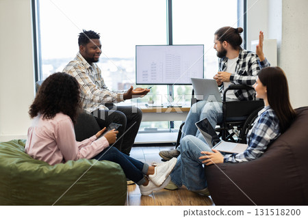Multiracial team discussing project ideas in office, including man wheelchair, in bright space Multiracial team discussing project ideas in office, including man wheelchair, in bright space 131518200