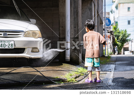 5-year-old boy washing a car with a pressure washer 5-year-old boy washing a car with a pressure washer 131518698