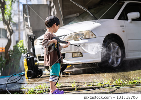 5-year-old boy washing a car with a pressure washer 5-year-old boy washing a car with a pressure washer 131518700