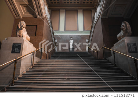 Elegant interior staircase with stone lion statues, marble walls, and intricate ceiling designs in a historic London cultural institution. Elegant interior staircase with stone lion statues, marble walls, and intricate ceiling designs in a historic London cultural institution. 131518771