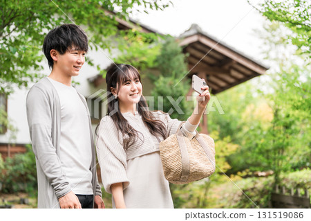 Young Asian couple visiting a tourist spot and searching information on their smartphone (apps, travel, tourism, gourmet) 131519086