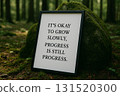 IT IS OKAY TO GROW SLOWLY, PROGRESS IS STILL PROGRESS, Framed inspirational quote on rock background symbolizing transition. 131520300