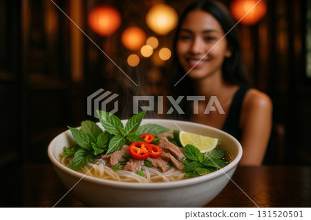 Steaming Beef Pho with Herbs and Chili in Cozy Lantern-Lit Eatery 131520501