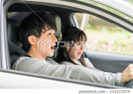 A male driver about to have a traffic accident as he brakes suddenly and a woman in the passenger seat screams in fear A male driver about to have a traffic accident as he brakes suddenly and a woman in the passenger seat screams in fear 131521074