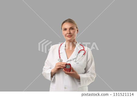 Doctor with stethoscope poses with medical equipment in clinic Doctor with stethoscope poses with medical equipment in clinic 131521114